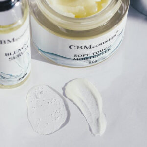 Blemish serum and Soft Touch moisturizer by CBMcosmetics, with product textures shown on a white surface. Ideal for skincare routines.