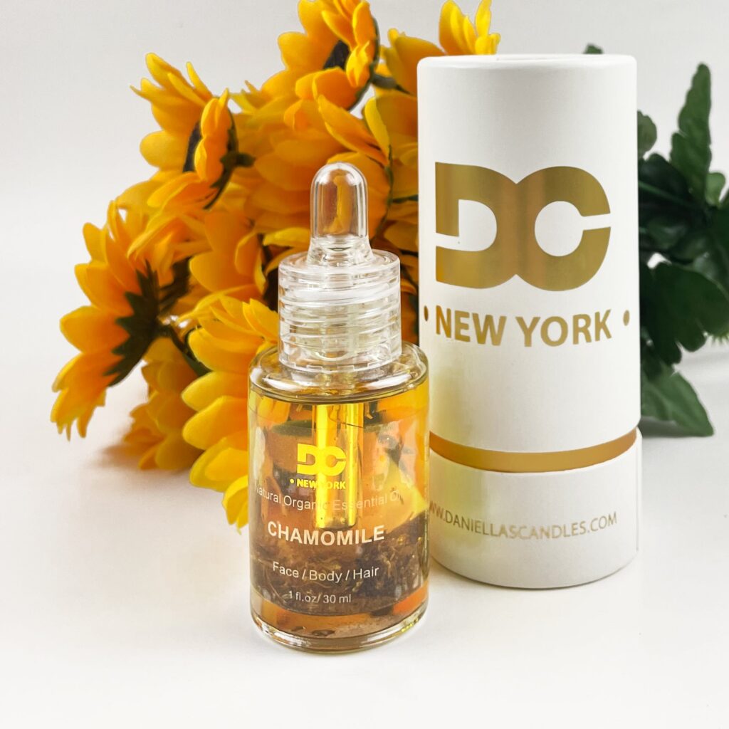 Chamomile essential oil bottle beside sunflowers, emphasizing its use for face, body, and hair care. Ideal for natural skincare solutions.