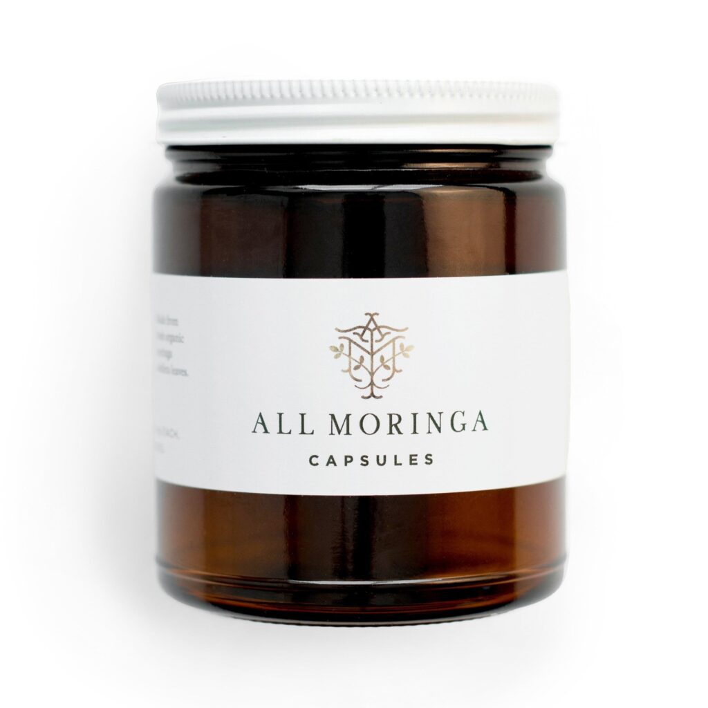 Amber jar of "All Moringa Capsules" with a sleek white label, showcasing its organic health benefits. Suitable for wellness enthusiasts.